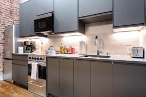 a kitchen with stainless steel appliances and a brick wall at Hollyhock Suite 403 in Louisville +10 photos