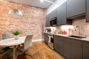 a kitchen with a table and a brick wall at Hollyhock Suite 403 in Louisville