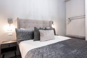 a bedroom with a large bed with gray pillows at Hollyhock Suite 403 in Louisville