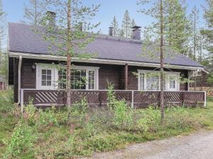 a wooden house with a porch in the woods at Holiday Home Kolonen by Interhome in Levi +13 photos