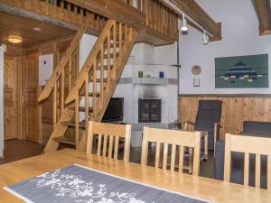 a living room with a staircase and a table and chairs at Holiday Home Albatrossi by Interhome in Levi +16 photos