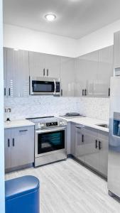 a kitchen with white cabinets and a stove top oven at Stylish Studio Apt-Outside NYC in West New York