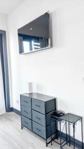 a dresser with a mirror and a table in a room at Stylish Studio Apt-Outside NYC in West New York