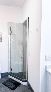 a glass shower stall in a white bathroom at Stylish Studio Apt-Outside NYC in West New York +6 photos