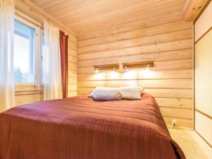 a bedroom with a bed in a wooden wall at Holiday Home Akavilla 2 by Interhome in Jämsä +13 photos