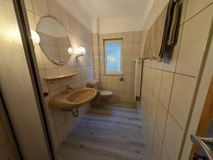 a bathroom with a sink and a toilet at Serviced Rooms ''Krone'' in Creglingen +17 photos