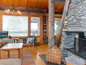 a living room with a stone fireplace in a log cabin at Holiday Home Sallanhelmi e2 by Interhome in Salla