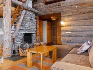 a living room with a fireplace in a log cabin at Holiday Home Sallanhelmi e2 by Interhome in Salla