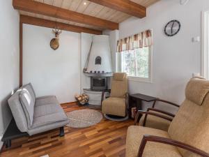 a living room with a chair and a fireplace at Holiday Home Golfväylä 3b - golf-osakkeen käyttöoikeus by Interhome in Levi