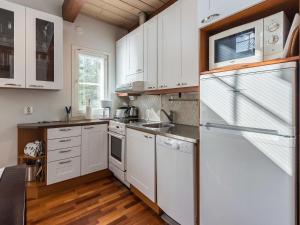 a kitchen with white cabinets and a white refrigerator at Holiday Home Golfväylä 3b - golf-osakkeen käyttöoikeus by Interhome in Levi +12 photos