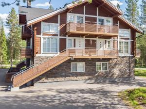 a house with a balcony and stairs on it at Holiday Home Golfväylä 3b - golf-osakkeen käyttöoikeus by Interhome in Levi