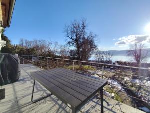 a wooden bench on a balcony with a view of the water at Ferienhaus Iris in Radolfzell am Bodensee