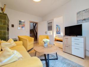 a living room with yellow furniture and a tv at Ferienhaus Iris in Radolfzell am Bodensee
