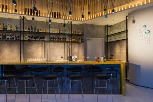 a bar with stools in a room with alcohol at Modena by Fraser Bangkok - SHA Extra Plus in Bangkok