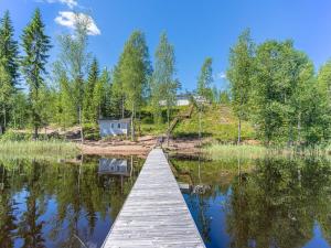 a dock on a lake with trees in the background at Holiday Home Valonsäde by Interhome in Valkeala