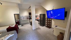 a living room with a large flat screen tv on the wall at Pousada Charmosa Lua Nova Pipa - Chales com Jacuzzi e Hidro in Pipa