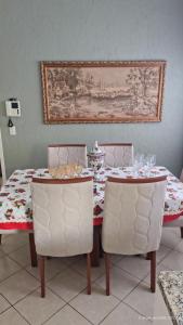 a dining room table with two chairs and a table with wine glasses at Raízes e Horizontes Hostel in Morungaba