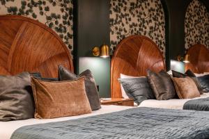 two beds in a hotel room with wooden headboards at Hollyhock Suite 404 in Louisville