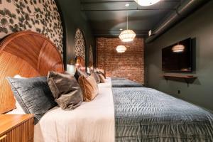 a bedroom with a large bed and a brick wall at Hollyhock Suite 404 in Louisville
