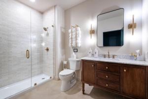 a bathroom with a toilet and a shower and a sink at Hollyhock Suite 404 in Louisville +5 photos