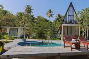 a villa with a swimming pool and a house at The Glade in Weligama