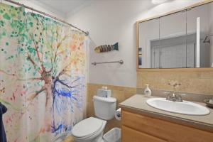 a bathroom with a tree shower curtain and a toilet at River Watcher Cottage in Bell +24 photos
