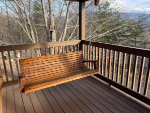 a wooden bench sitting on a porch with a view at Blushing Bear Stunning Views in Sevierville +6 photos
