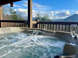 a jacuzzi tub with a glass of wine at Blushing Bear Stunning Views in Sevierville