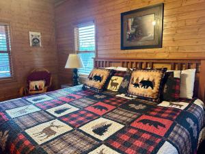 a bedroom with a bed with a quilt on it at Blushing Bear Stunning Views in Sevierville