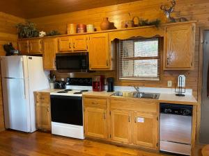 a kitchen with wooden cabinets and a white refrigerator at Blushing Bear Stunning Views in Sevierville