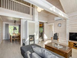 a living room with a couch and a table at Holiday Home Villa valo by Interhome in Kolinkylä