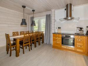 a kitchen with a wooden table and a dining room at Holiday Home Villa valo by Interhome in Kolinkylä +17 photos
