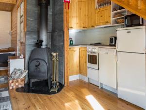 a kitchen with a stove and a refrigerator at Holiday Home Yllästokka 5 by Interhome in Ylläsjärvi