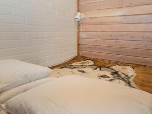 a dog laying on the floor next to a bed at Holiday Home Yllästokka 5 by Interhome in Ylläsjärvi +6 photos