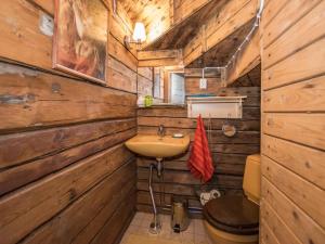 a bathroom with wooden walls and a sink and a toilet at Holiday Home Piispasen torppa by Interhome in Alastaro +6 photos
