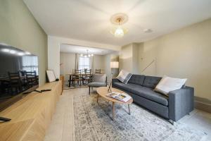 a living room with a blue couch and a table at Spacious 2-Bed House with Garden Office in Oxford