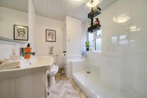 a bathroom with a tub and a sink and a toilet at Spacious 2-Bed House with Garden Office in Oxford