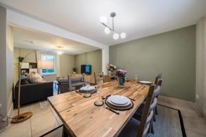 a dining room with a wooden table and chairs at Spacious 2-Bed House with Garden Office in Oxford