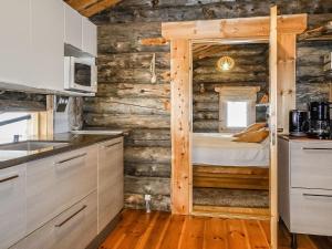 a kitchen with a bed in a wooden wall at Holiday Home Kelokota by Interhome in Salla