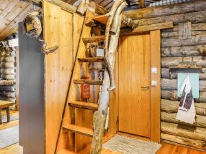 a wooden cabin with a spiral staircase in a room at Holiday Home Kelokota by Interhome in Salla