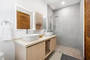 a bathroom with two sinks and a shower at Panaromic Oceanview Luxury 3BR Private Rooftop in Tamarindo +23 photos