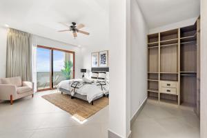 a white bedroom with a bed and a chair at Panaromic Oceanview Luxury 3BR Private Rooftop in Tamarindo