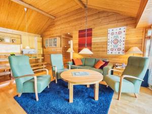 a living room with a table and chairs at Holiday Home Sinikuono by Interhome in Ylläsjärvi
