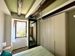 a bedroom with a bed with a mirror and a window at Residenza Renata in Onno