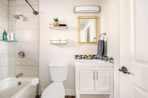 a bathroom with a toilet and a sink and a mirror at 721 Cozy Mid-Town Hideaway in Reno +20 photos