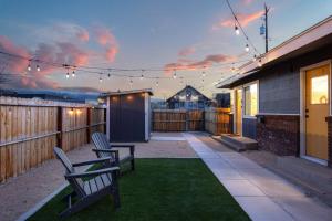 a patio with two chairs and a fence with lights at 721 Cozy Mid-Town Hideaway in Reno