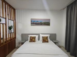 a bedroom with a large white bed with pillows at Bark luxury apartments Abidjan Attoban 2 in Abidjan +6 photos
