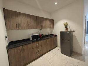a kitchen with wooden cabinets and a refrigerator at Bark luxury apartments Abidjan Attoban 2 in Abidjan