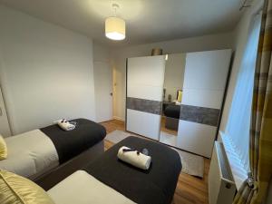 a bedroom with two beds and a large mirror at Modern 2BR Cottage Flat in Bellshill