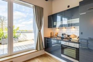 a kitchen with a large window with a view at LÜTTES LOFT Boutique Hotel in Eckernförde